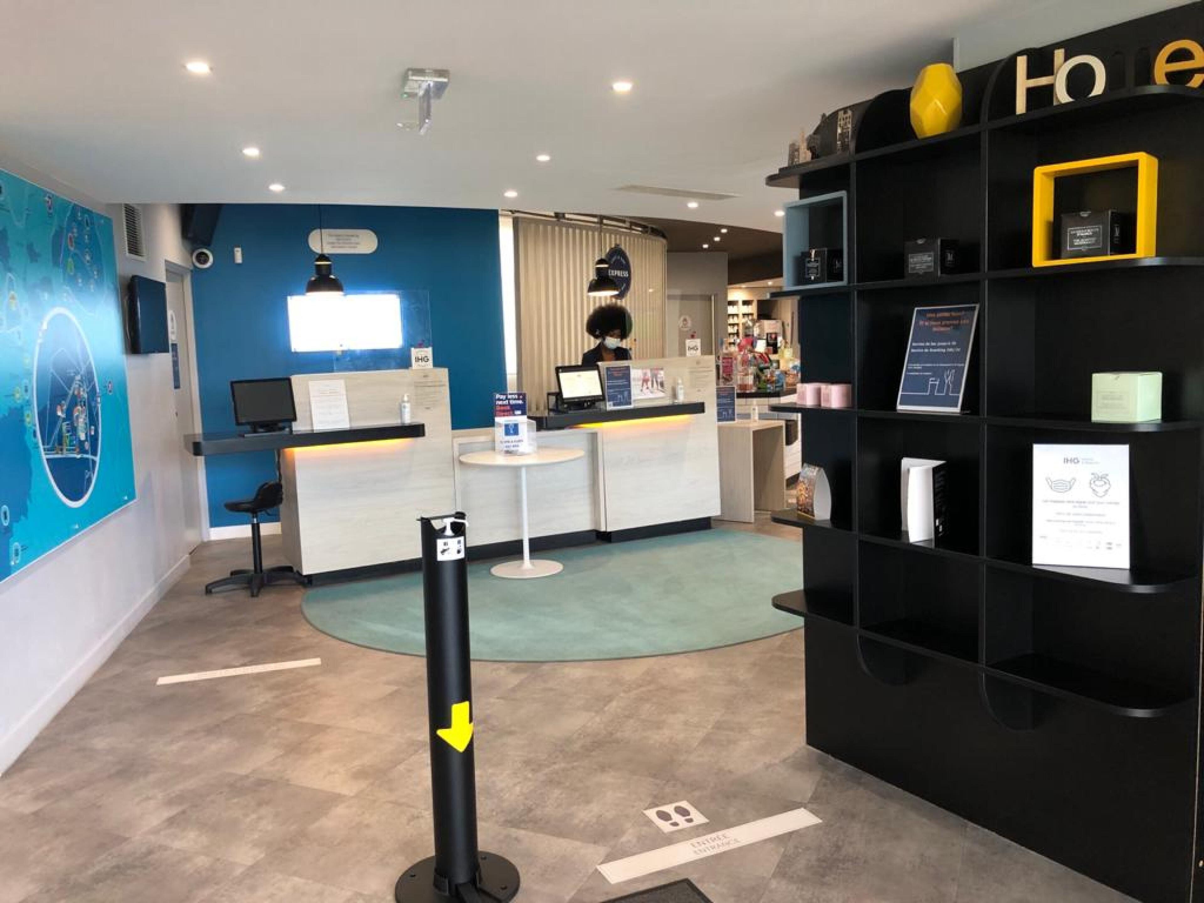 A reception area with a desk, computer, and a black wall with yellow accents.