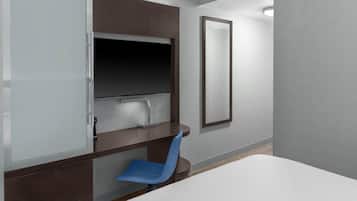A modern hotel room with a bed, a desk with a chair, a large mirror, and a wardrobe.