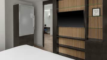 Una habitación de hotel moderna con una cama grande, un armario, un televisor y un separador con listones verticales.