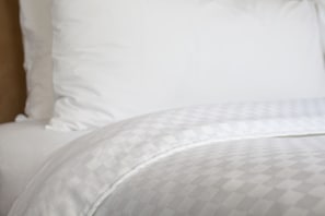 A bed with a patterned bedspread and pillows. - Four Points By Sheraton New York Downtown (New York)