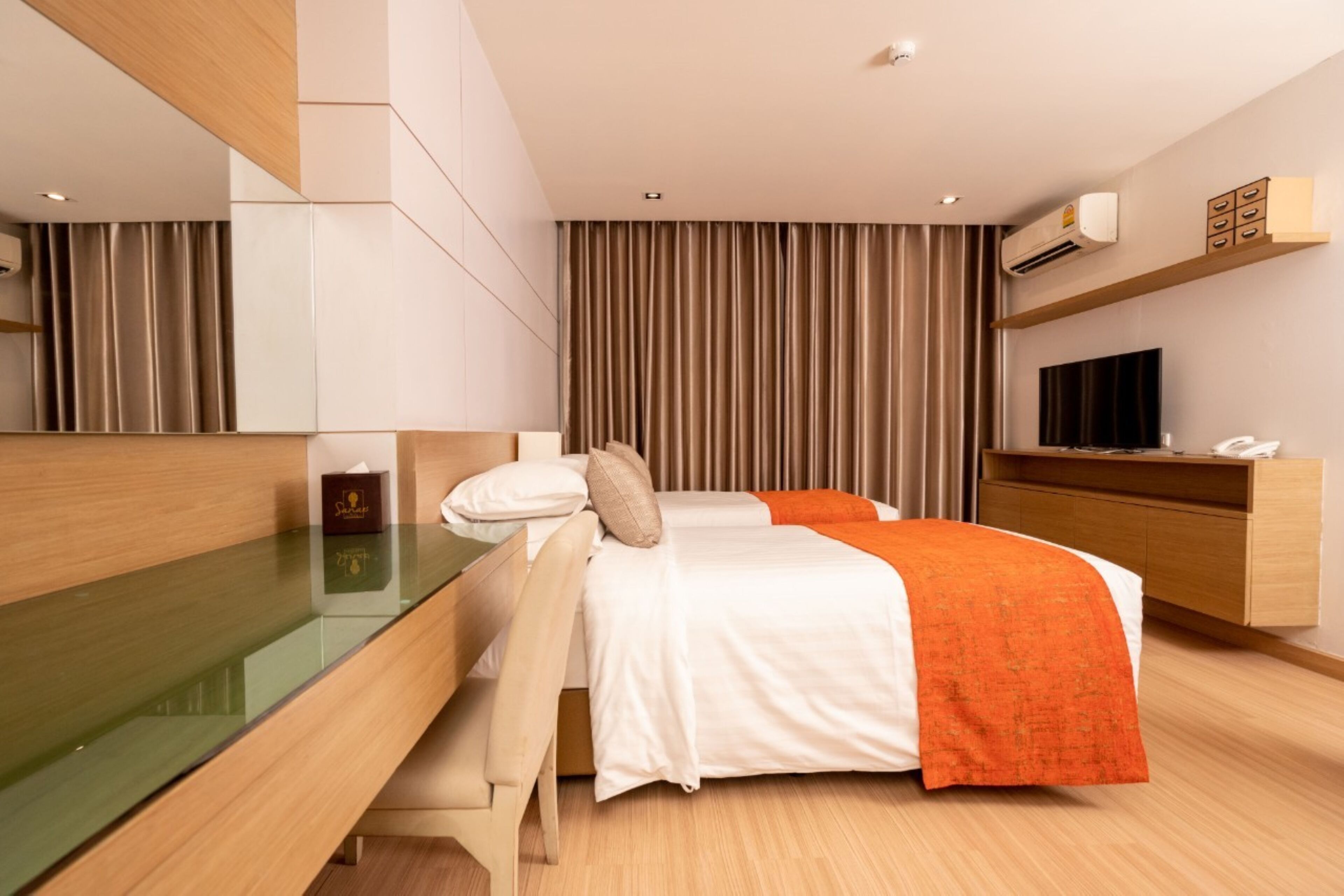 A modern hotel room with a bed, bedside table, and a TV.
