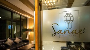 A modern interior with a glass partition displaying the logo 'Sanae Chiangmai'. - Sanae' Hotel Nimman (Chiang Mai)