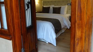 Une chambre à coucher avec un lit, une porte en bois et un luminaire fixé au mur.