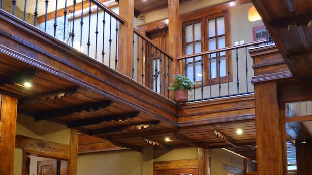 Un intérieur spacieux avec un escalier en bois, un coin repas et une vue sur l’extérieur.