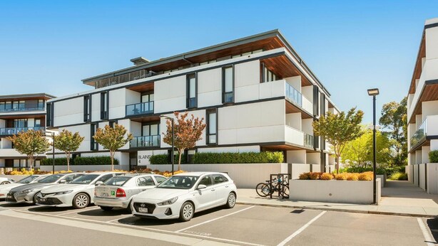 A modern multi-story residential building with a parking lot in front. - Clayton Serviced Apartments (Clayton)