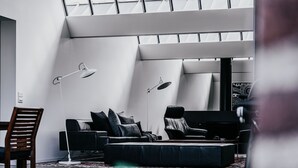 A modern living room with a sofa, chairs, and floor lamps. - Alkina Lodge (Wattle Hill)