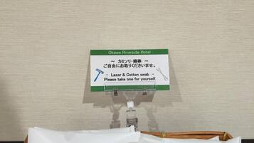 Une pancarte indiquant l’emplacement de l’hôtel Okawa Riverside et précisant qu’il faut prendre un rasoir et des cotons-tiges pour un usage personnel.