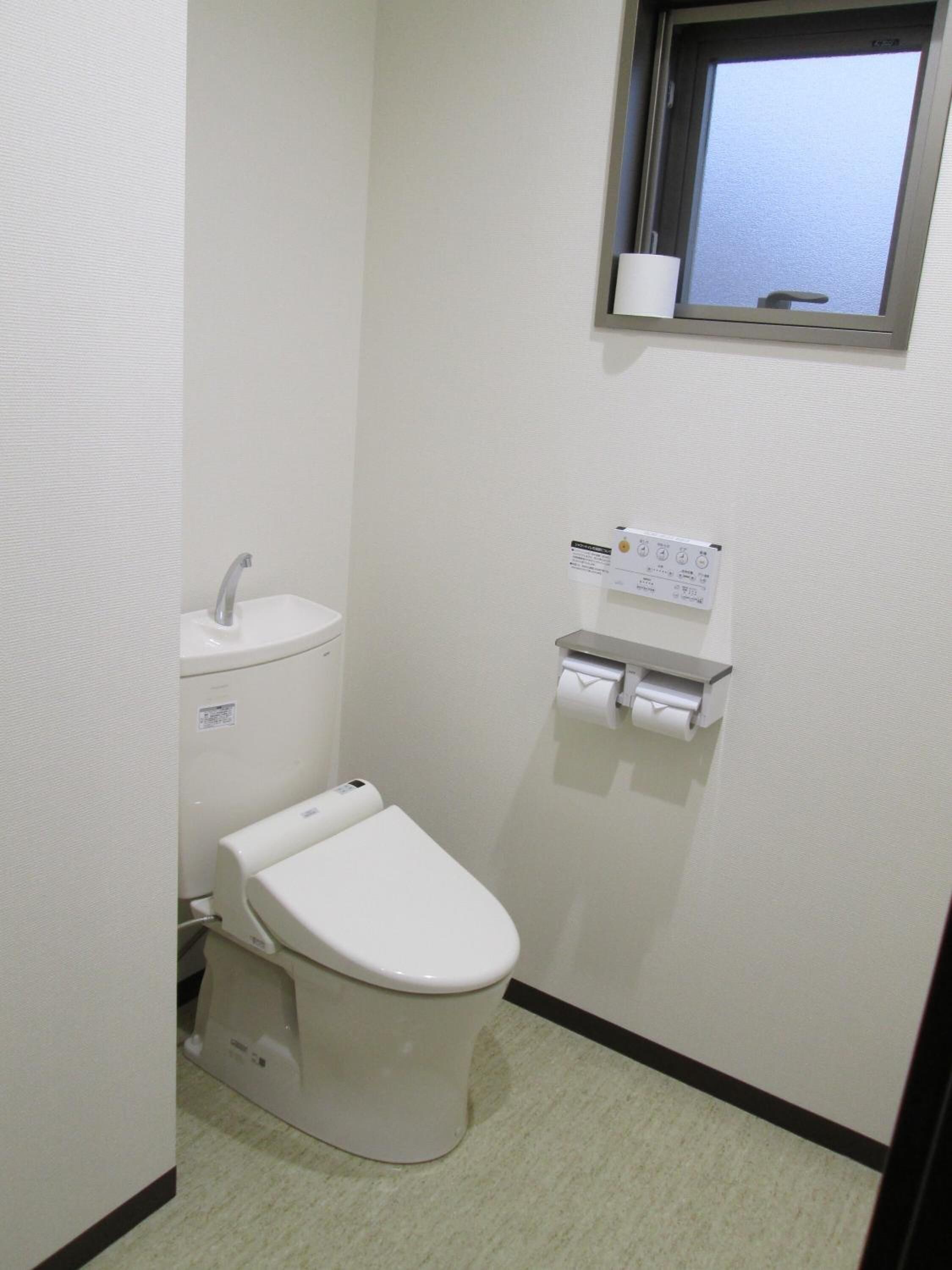 Un baño pequeño y limpio con inodoro, lavamanos y ventana.