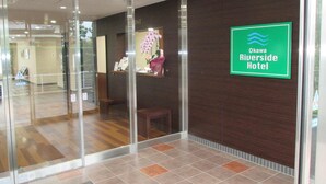 A hotel reception area with a glass door entrance, a reception desk, and a sign for Okawa Riverside Hotel. - Okawa Riverside Hotel (Okawa)