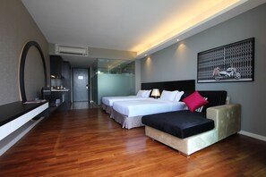 Une chambre d’hôtel avec deux lits, un canapé, un bureau avec un miroir et une œuvre d’art accrochée au mur.