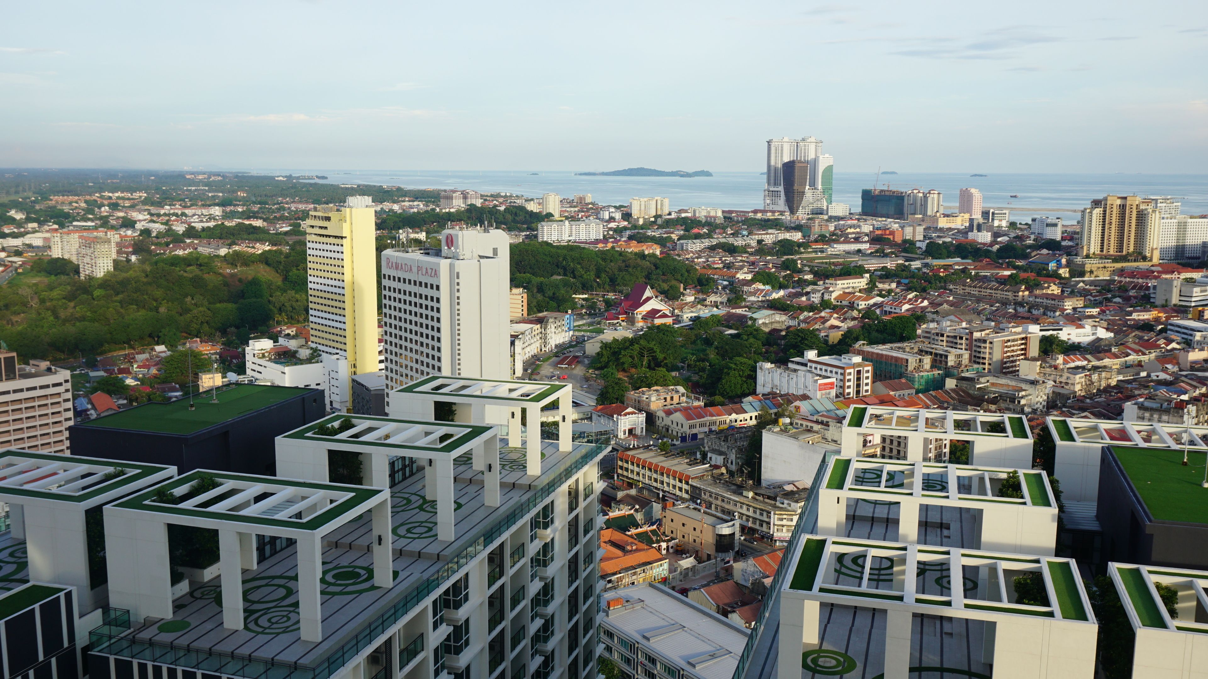 A high-rise building with a modern design, featuring multiple balconies and a rooftop garden.