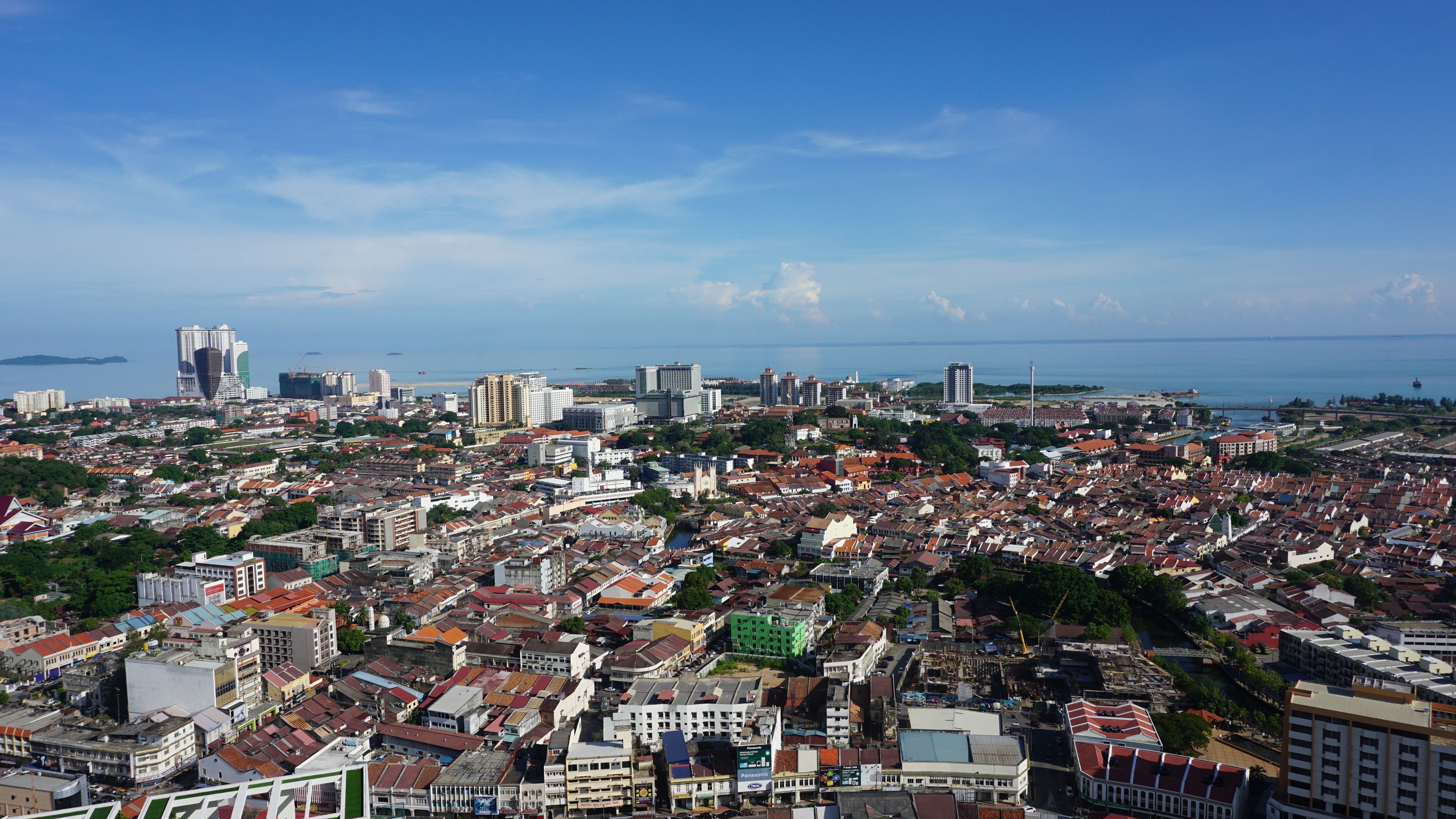 Una vista panorámica de una ciudad costera con un desarrollo urbano denso, que incluye diversos estilos arquitectónicos y un importante frente marítimo.