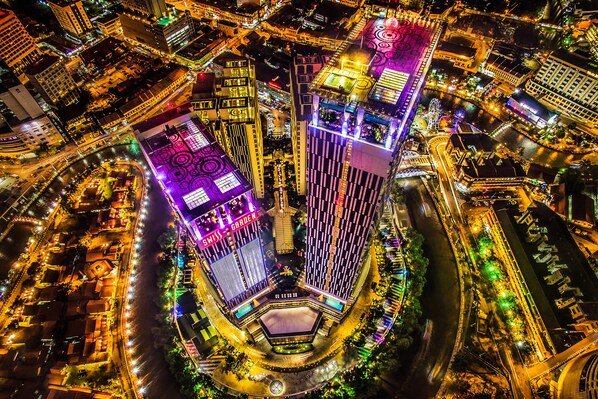 An aerial view of a cityscape with illuminated buildings and a river.
