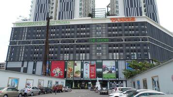 A modern building with multiple floors, featuring a prominent sign for 'TANGS' and 'THE SHORE'.