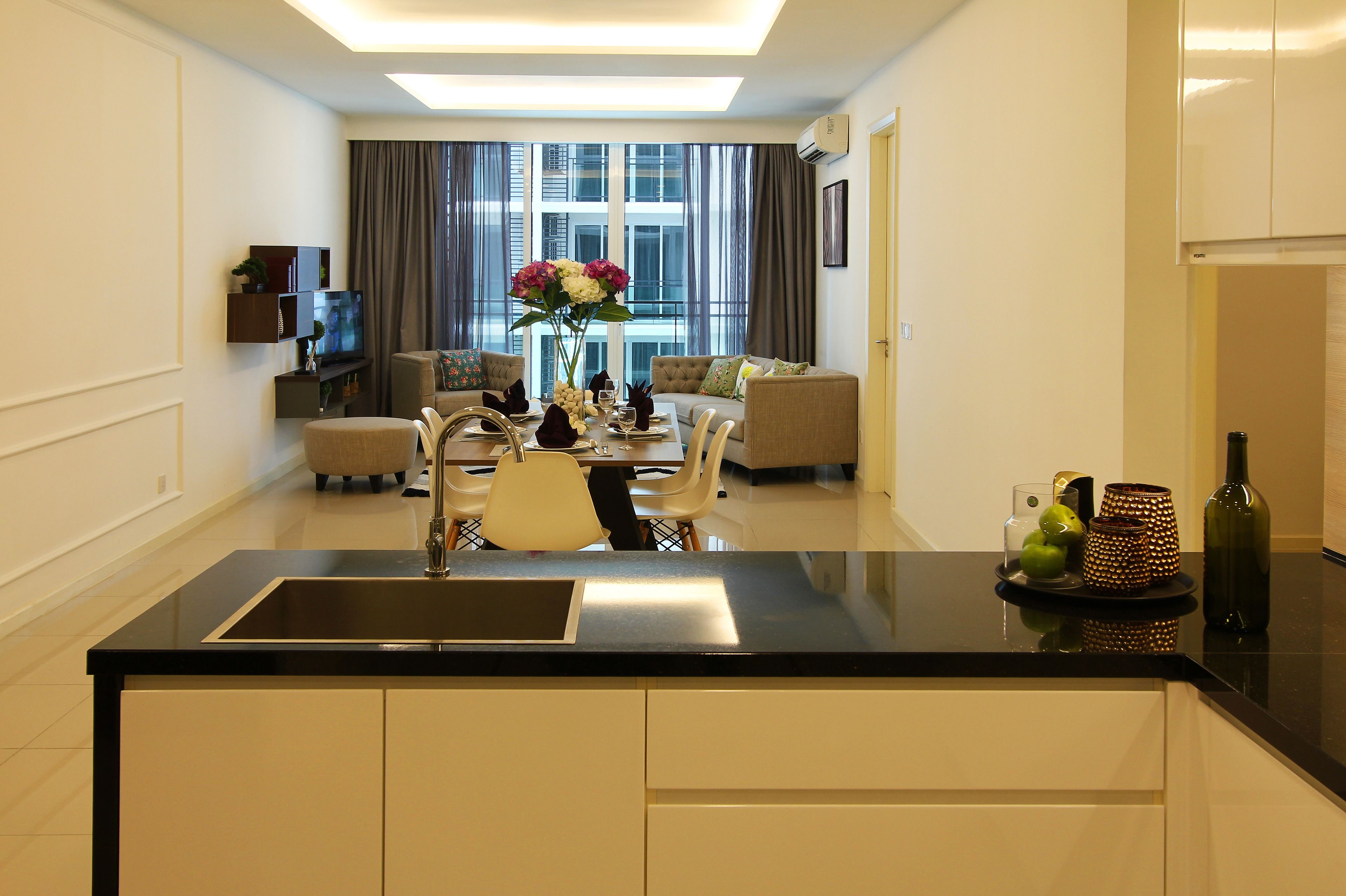 Een moderne keuken met een centraal kookeiland, een eethoek met stoelen en een bank.