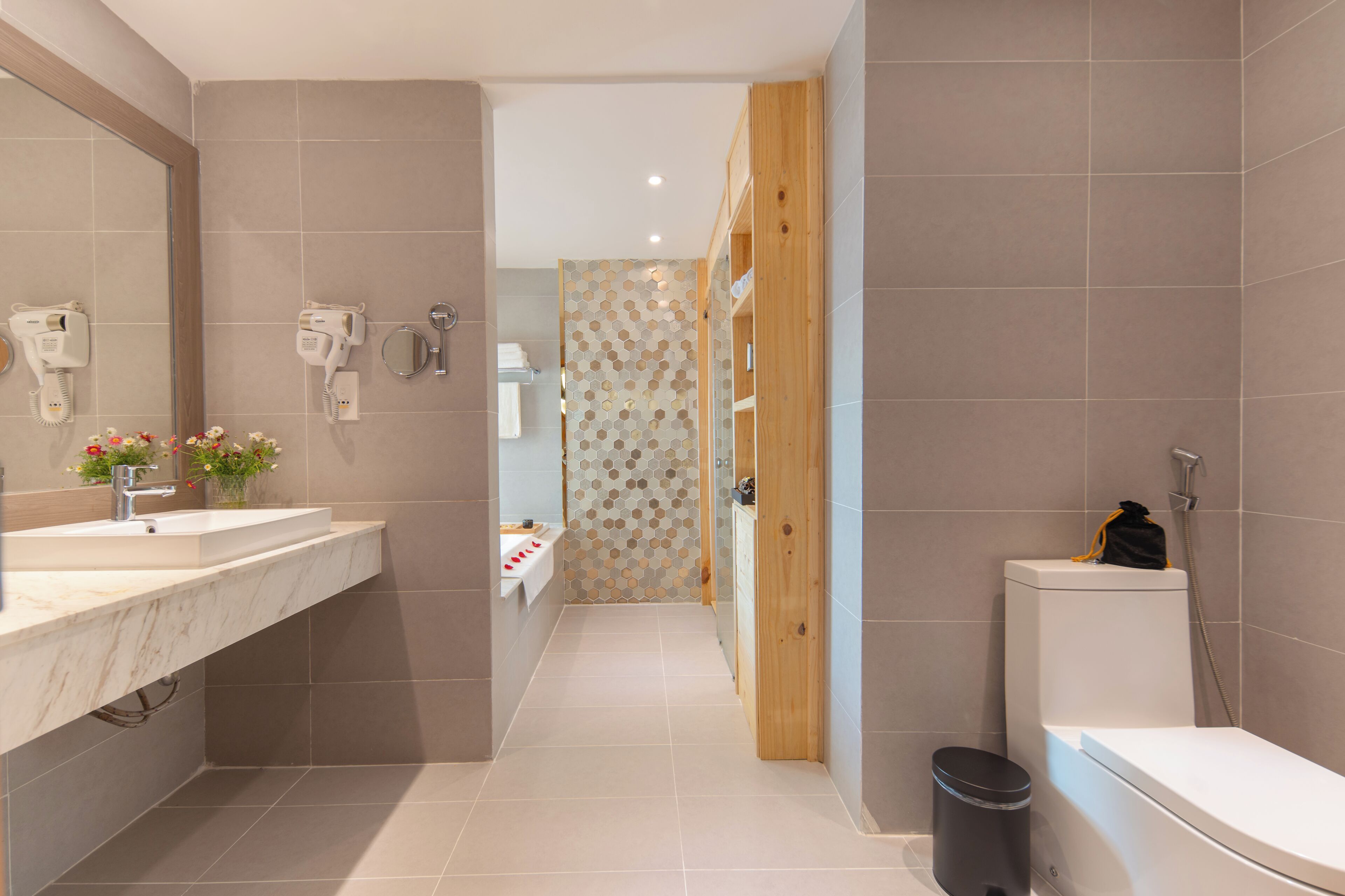 A modern bathroom with a marble sink, a toilet, and a shower area.