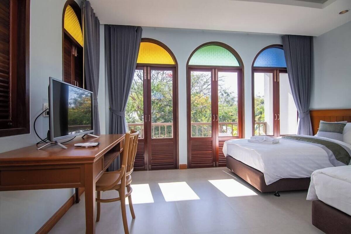 Une chambre d’hôtel équipée d’un bureau, d’un lit et d’une télévision.