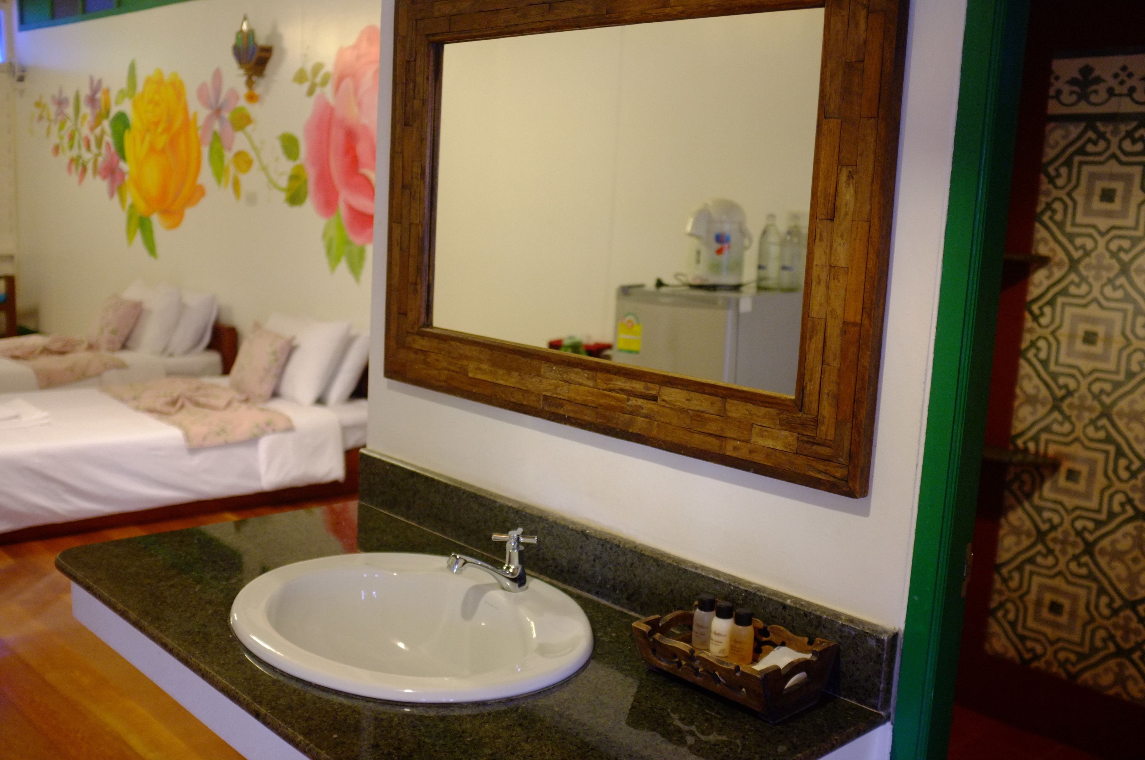 Un baño con un espejo grande, un lavabo y un tocador de madera.