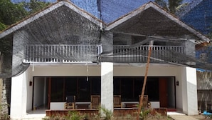 A two-story house with a covered porch and a garden in front. - Villa Bintang (Gili Trawangan)