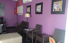 A room with purple walls, wicker furniture, and artwork depicting zebras. - Micasa Hotel (Labuan)