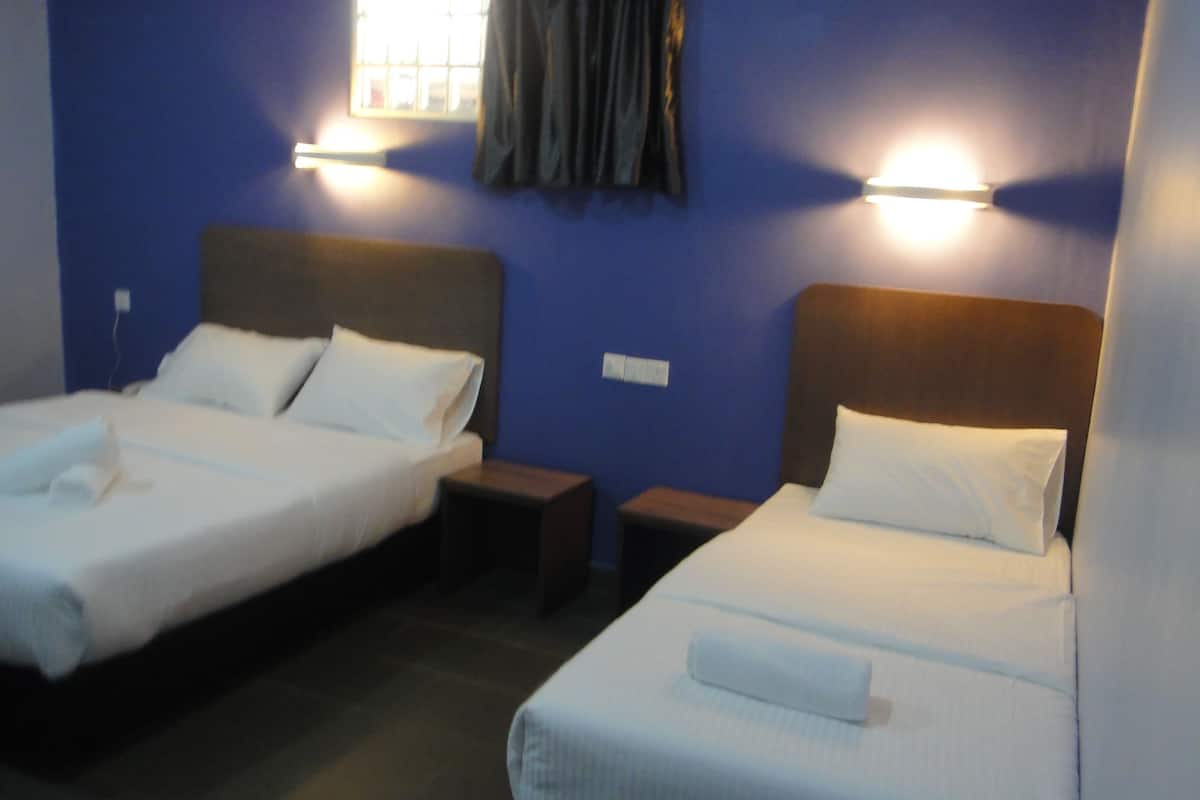 Two single beds with white linens, wooden headboards, bedside tables, and wall-mounted lights.