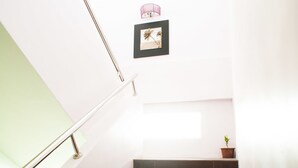 A staircase with a handrail, a potted plant, and a framed picture on the wall. - Micasa Hotel (Labuan)