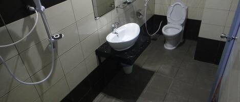 Un baño con lavamanos, inodoro y espejo.