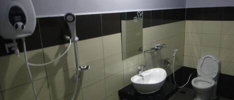 Un baño con secamanos, lavabo y retrete.
