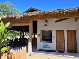 Un bâtiment doté d’un toit de chaume, d’une porte en bois et d’une fenêtre.