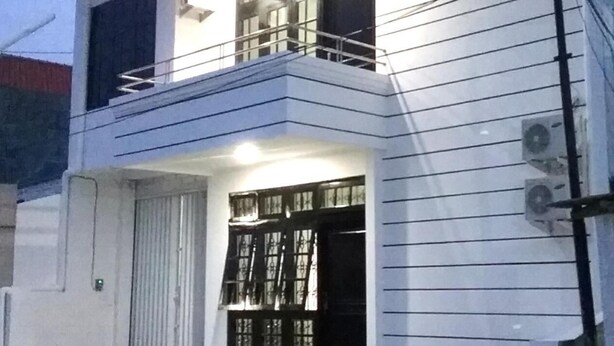 A modern two-story house with a balcony, large windows, and a well-lit entrance. - Mess Inn Semarang (Semarang)