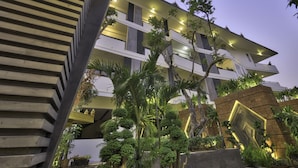 A modern multi-story building with balconies, surrounded by lush greenery and well-maintained plants. - Central Suite Residence (Siem Reap)