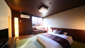 A hotel room with a bed, a desk, a chair, a TV, and a window with blinds. - Nasu Ichiya Hotel (Nasu)