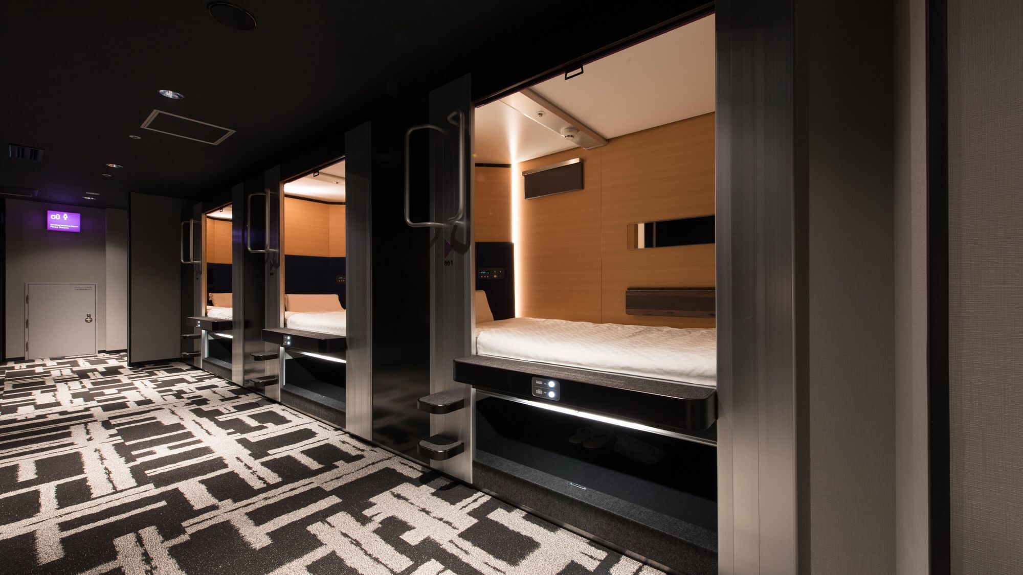 A hotel room with bunk beds, a patterned carpet, and a modern design.