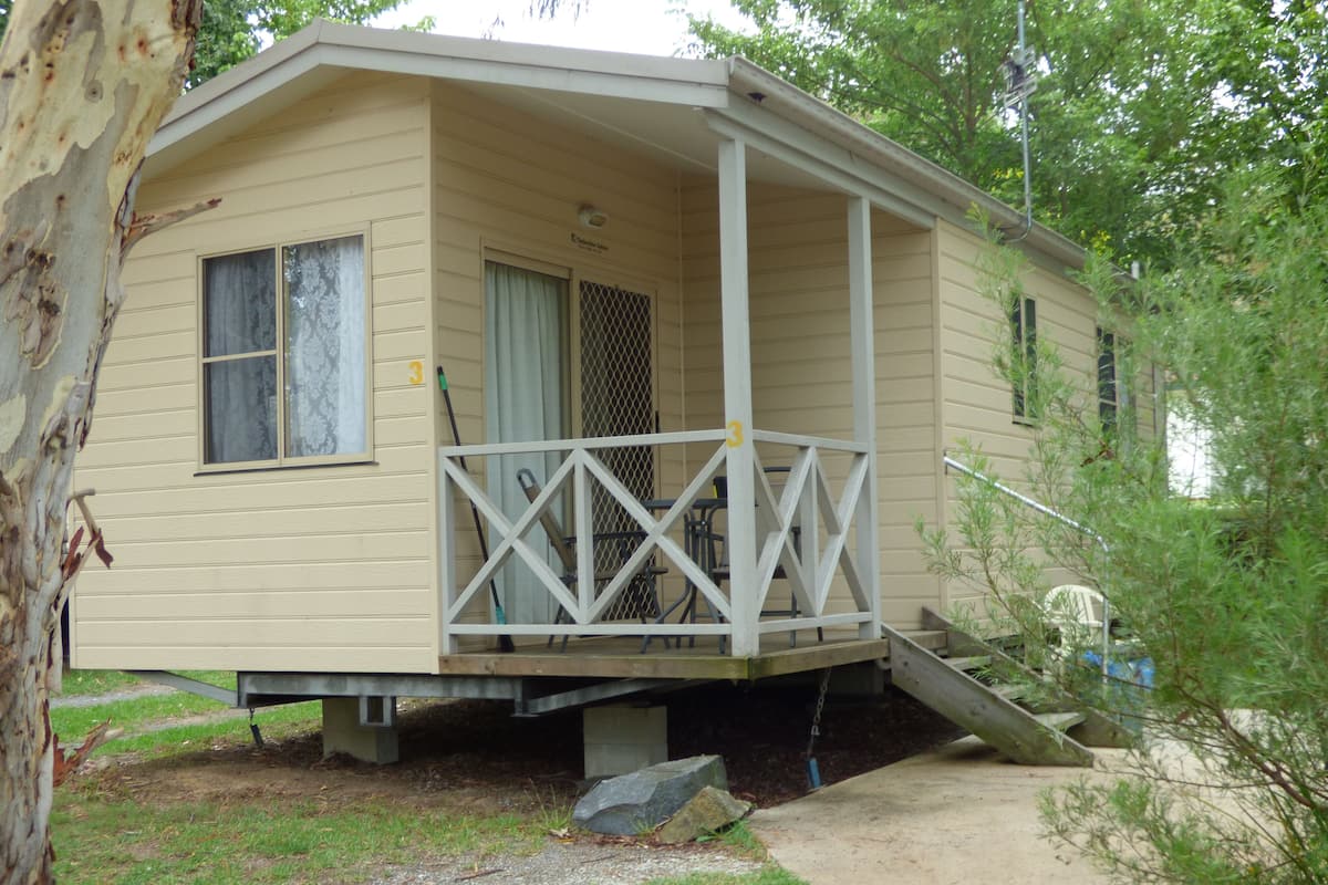 A small, single-story cabin with a porch and a covered entryway.