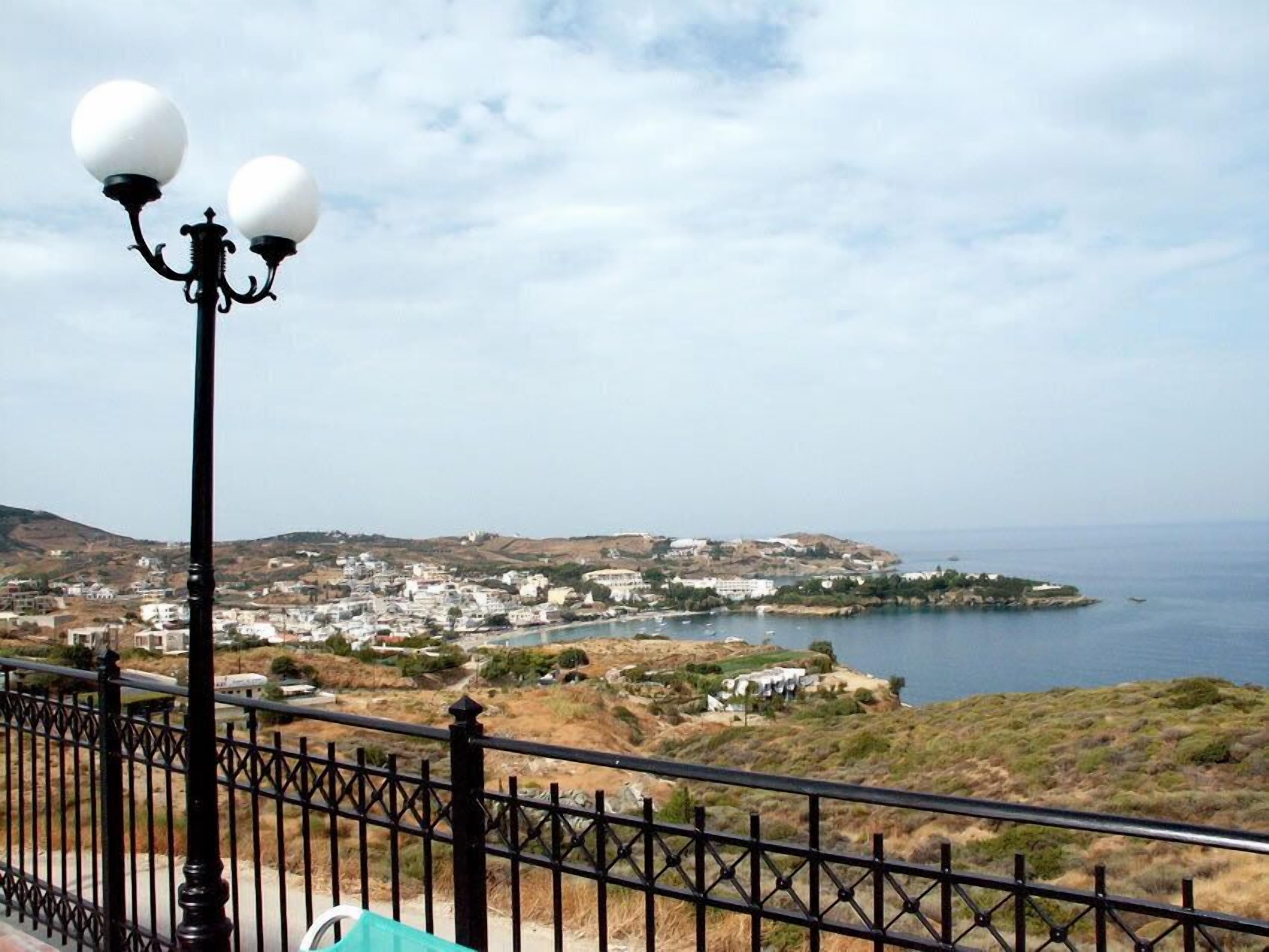 A coastal town with a view of the sea and hills in the background.