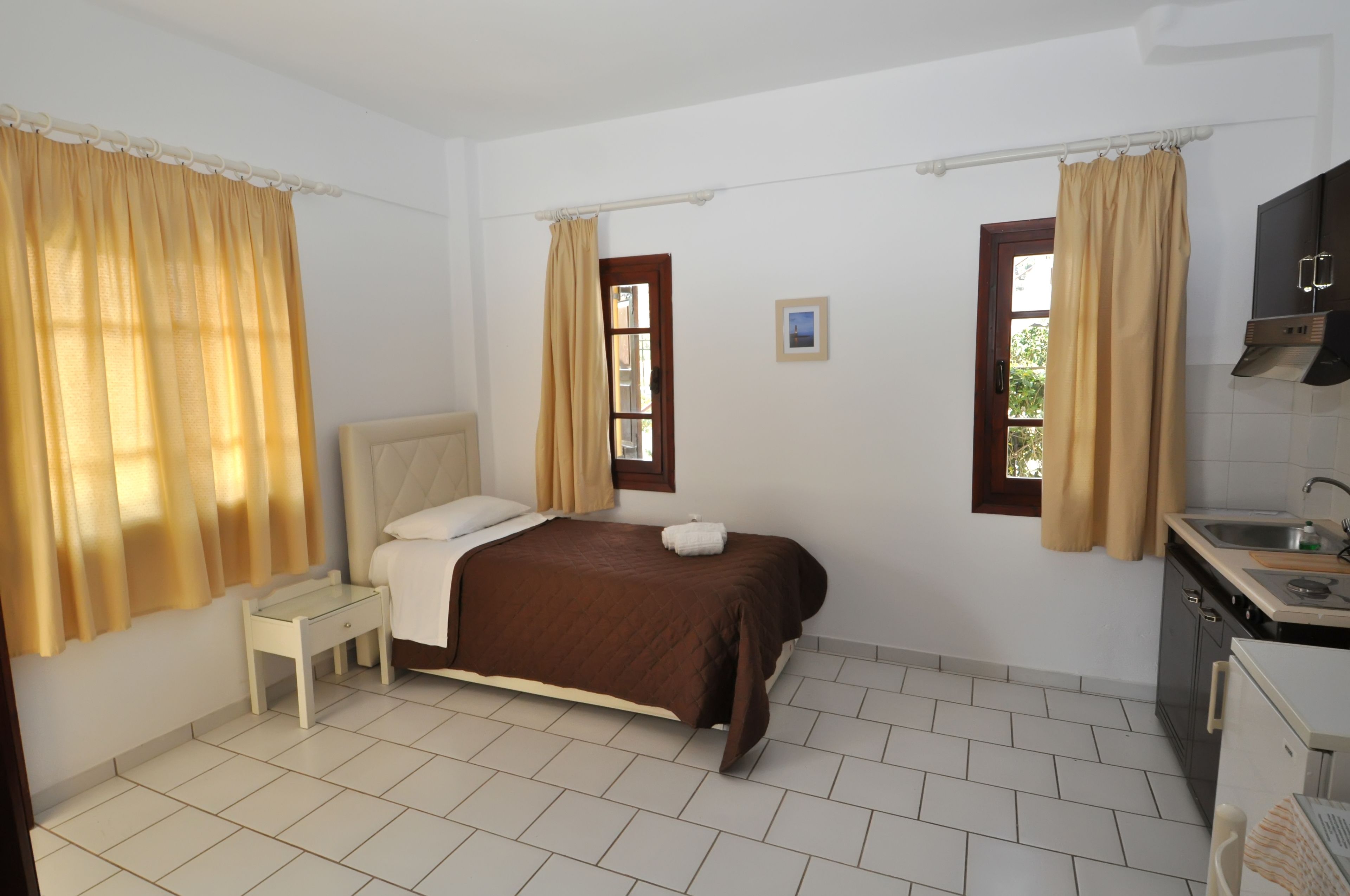 Una camera da letto con un letto, un comodino e una piccola finestra.