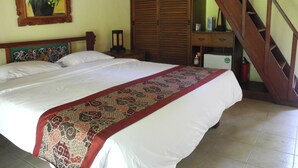 A bedroom with a large bed, a wooden wardrobe, a desk with a chair, and a staircase. - Villa Jineng Ubud Bali (Ubud)