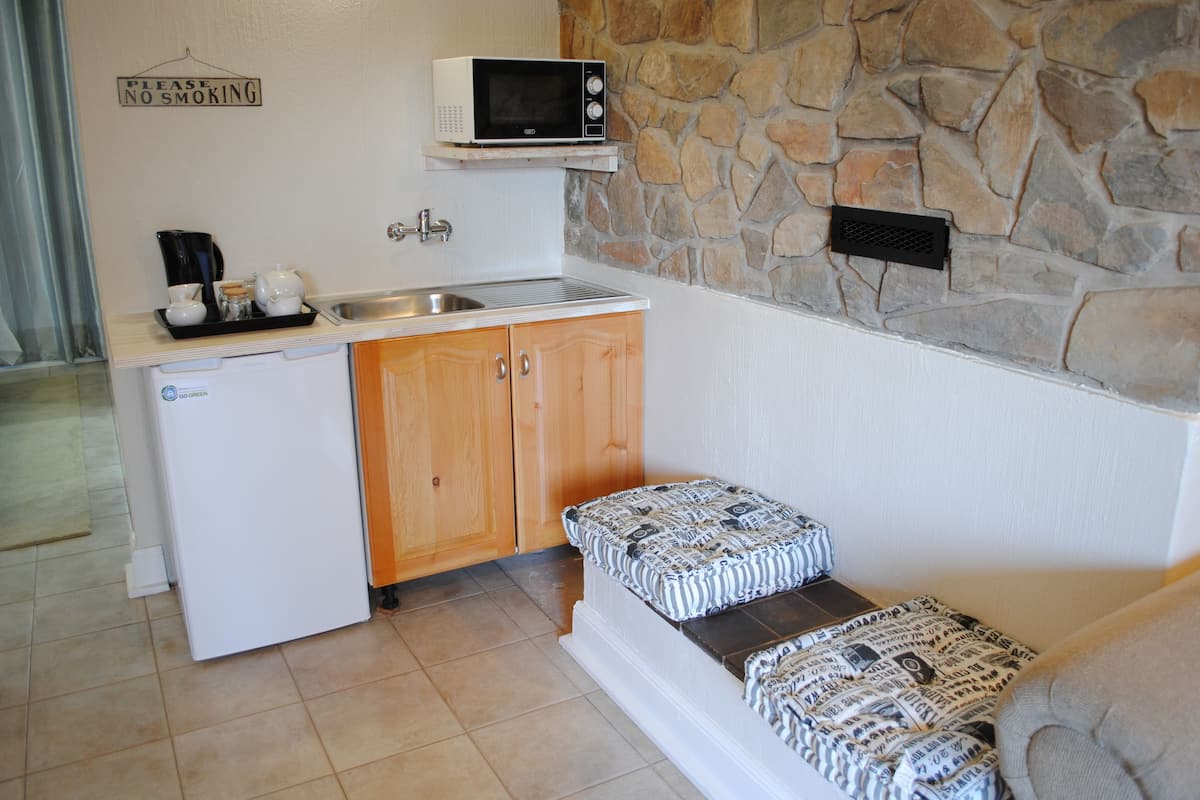 A compact kitchenette with a microwave, sink, and a small refrigerator.