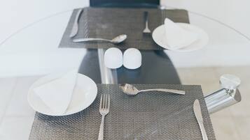 A table set with a placemat, plates, cutlery, and salt and pepper shakers.
