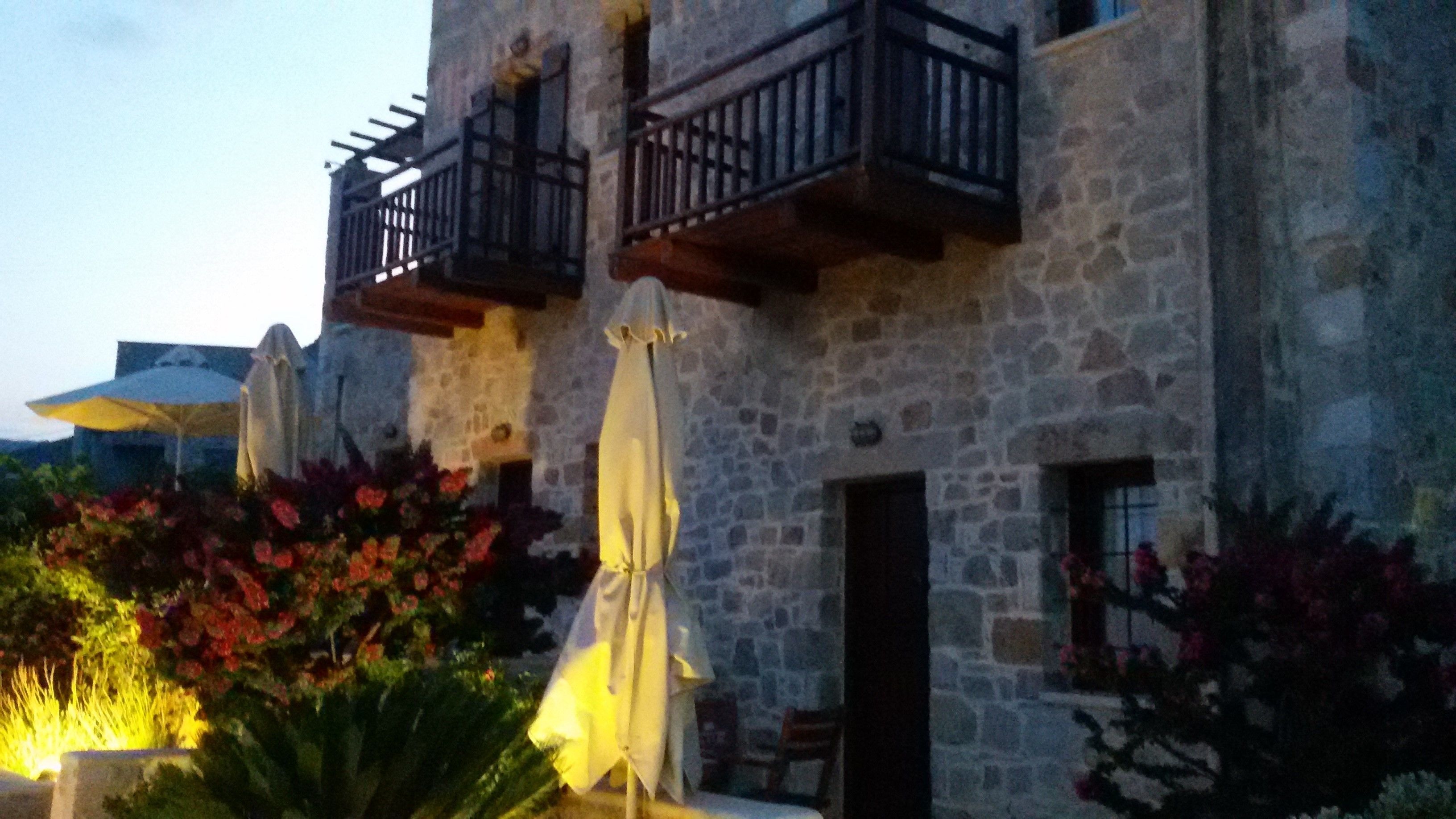 A stone building with outdoor seating and umbrellas.