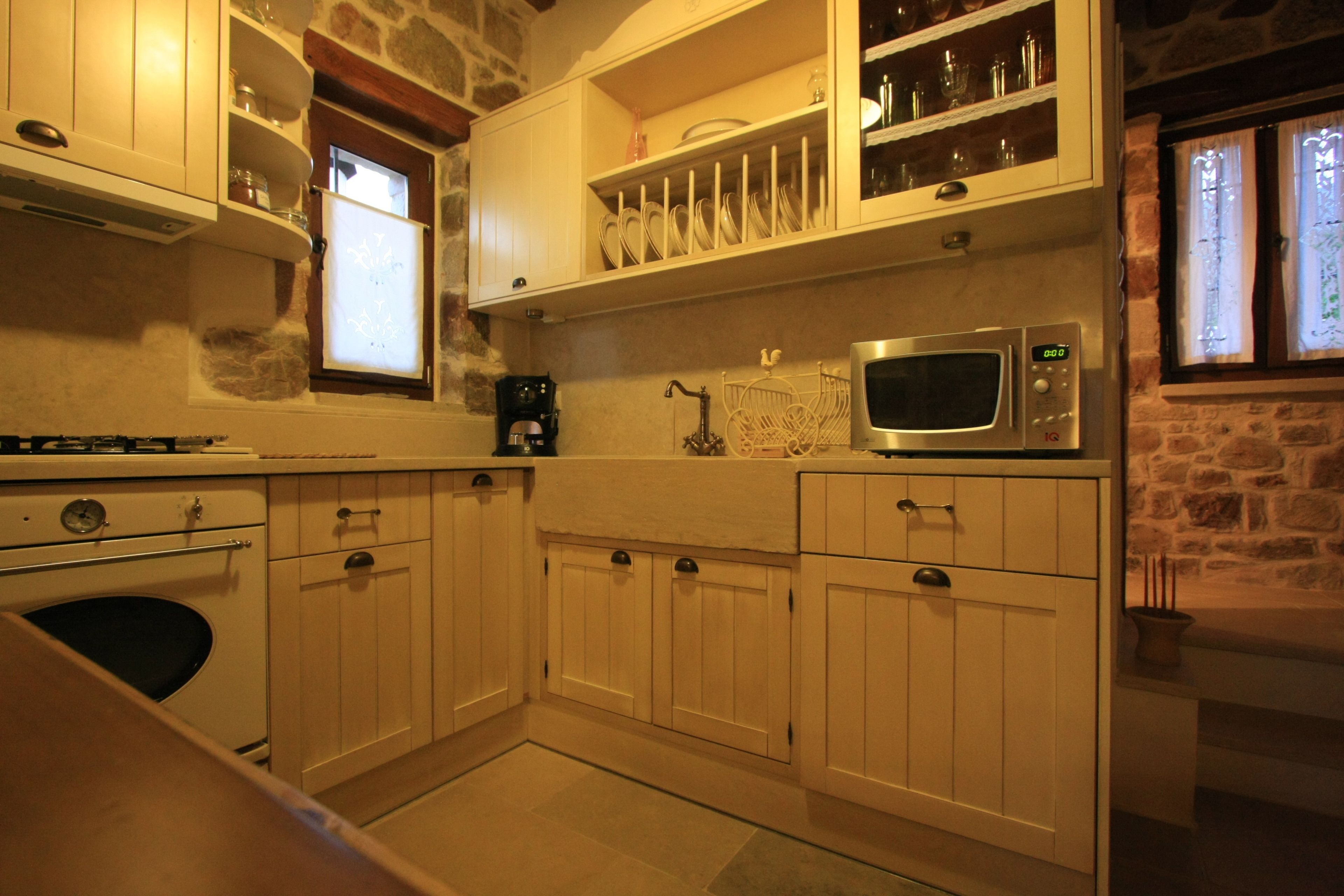 A kitchen with white cabinets, a microwave, and a coffee maker.