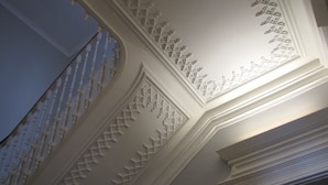 A ceiling with intricate white decorative moldings and a balustrade. - Koolhouse Porto (Porto)