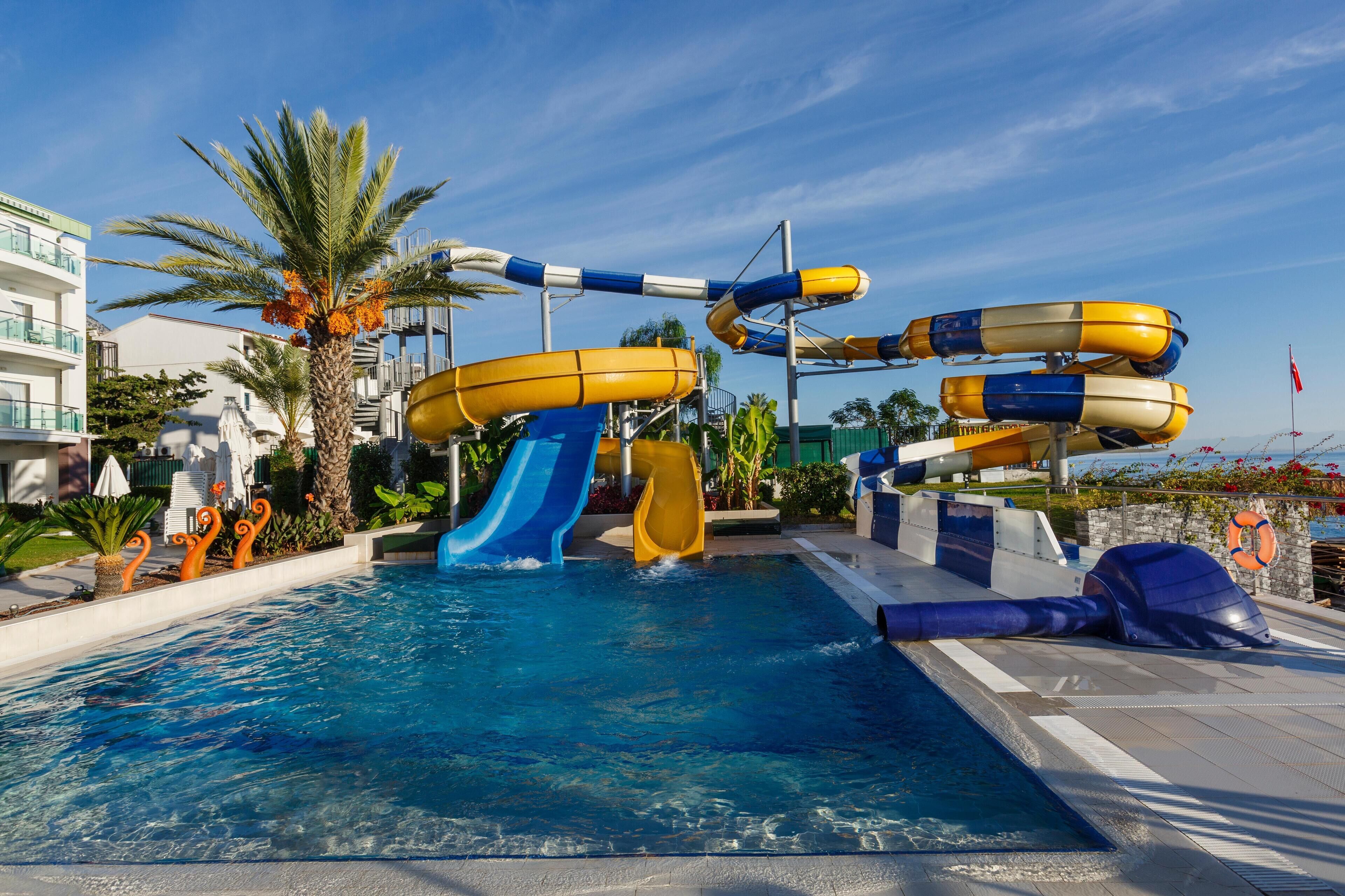 Alberca techada, alberca al aire libre y sombrillas en la alberca