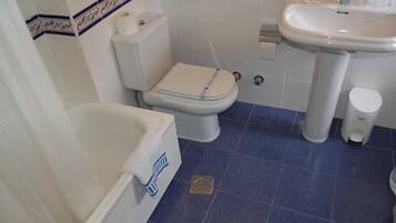 A bathroom with a toilet, sink, and bathtub.
