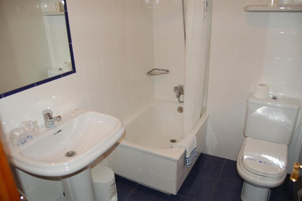 Ein Badezimmer mit Waschbecken, Badewanne, Toilette und Spiegel.