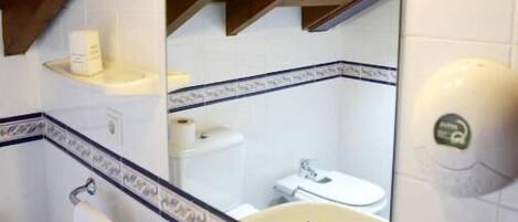 A bathroom with a white sink, a mirror, and a towel rack.