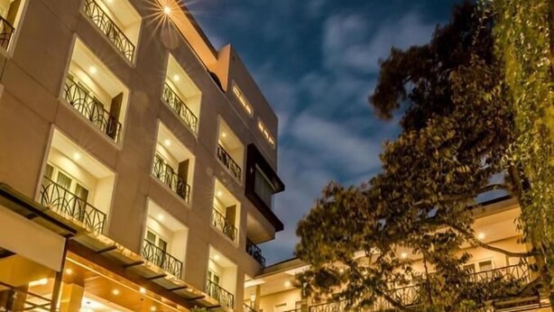 Un hôtel doté d’une piscine, d’un espace extérieur aménagé et de plusieurs balcons.