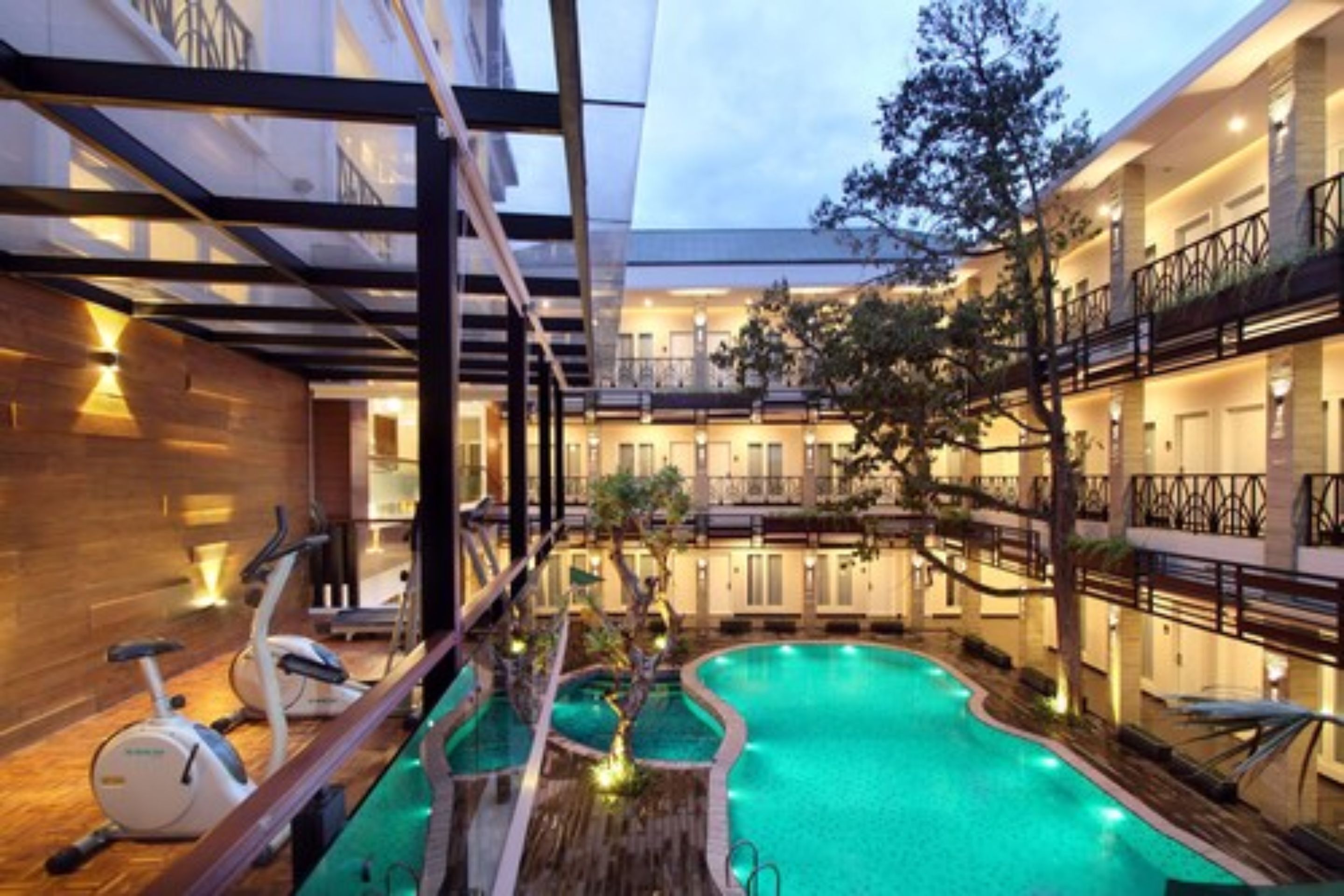 Un hotel con piscina, bicicletas estáticas y terraza de madera.