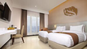 Une chambre d’hôtel avec un grand lit, un bureau et une télévision.