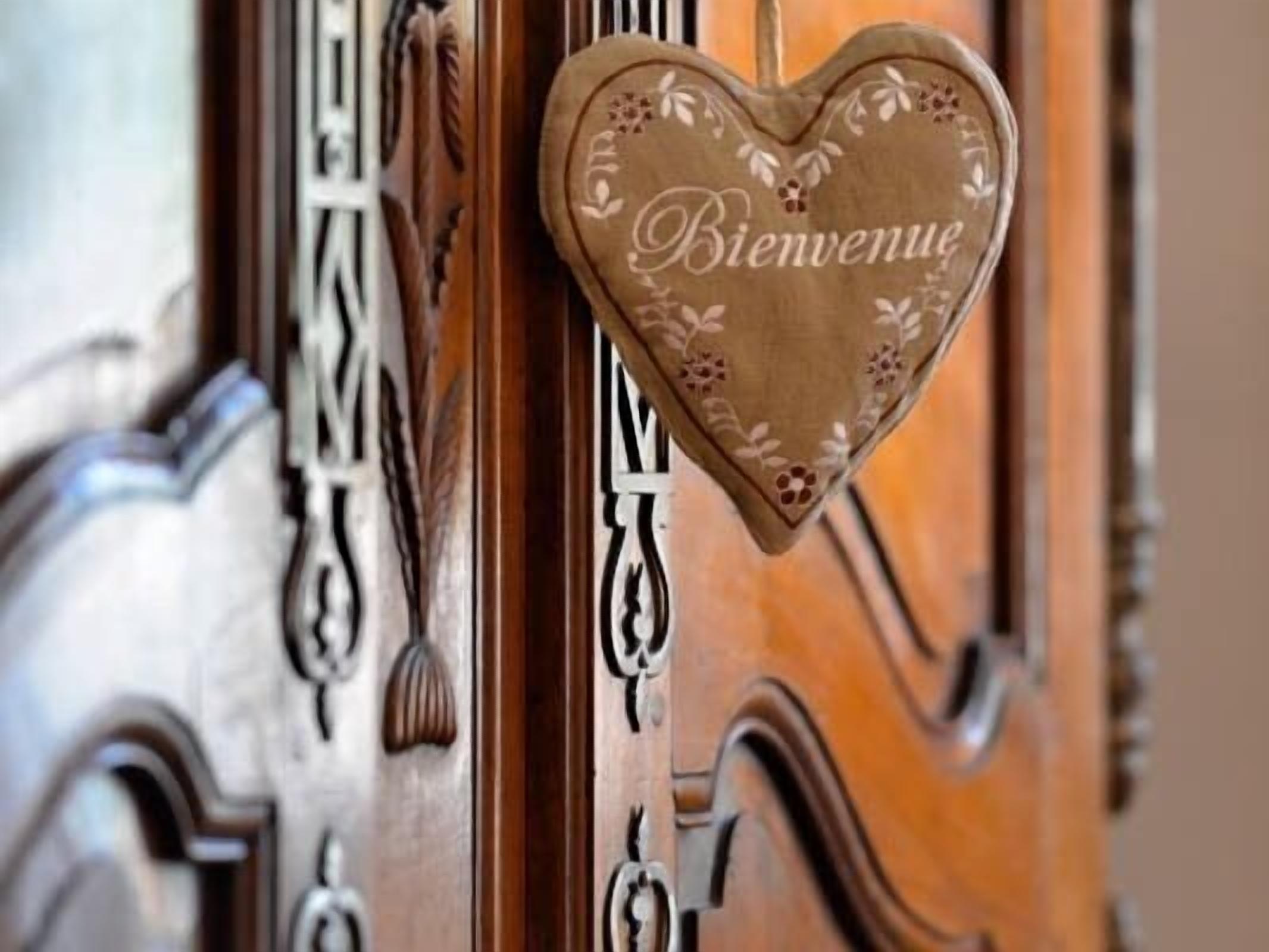 A wooden door with a heart-shaped welcome sign.